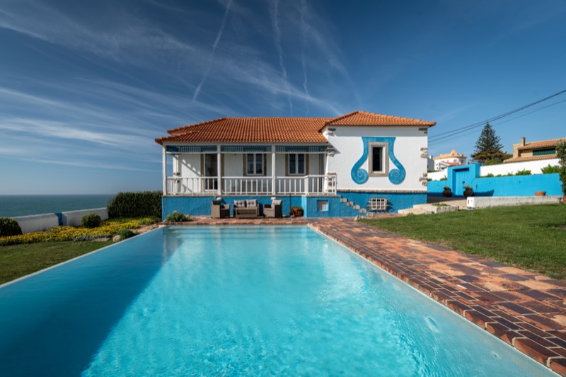 Front view of the villa with pool and lawn