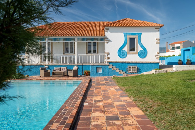 The villa seen across the pool, ocean wall and flowering garden