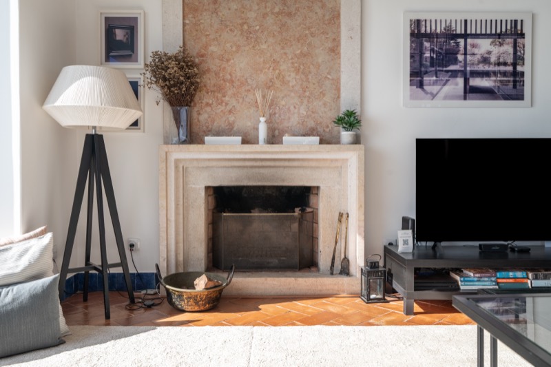 Stone fireplace with terracotta floor and reading lamp