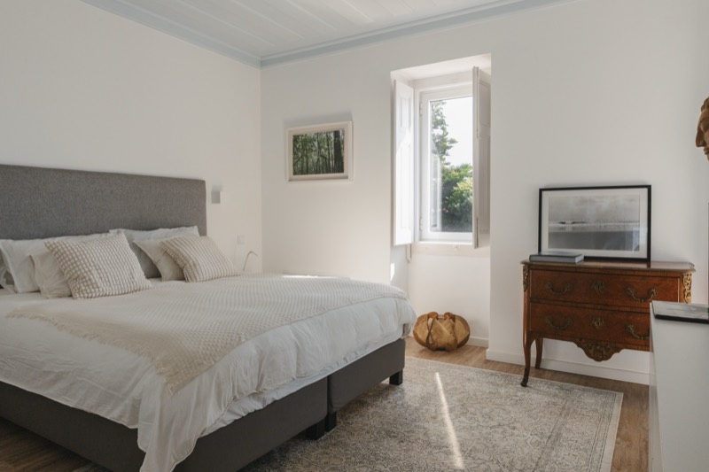 King-size bed in the suite, morning light through the shutters