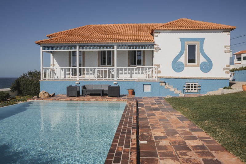 Villa facade detail with the blue scrollwork ornament and the pool below