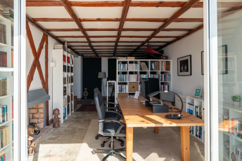 Beamed studio with library and long wooden desk
