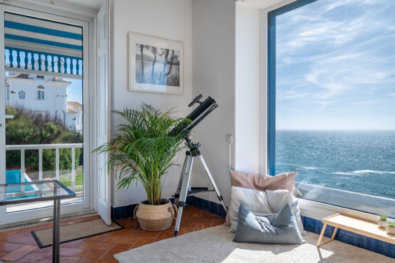 Telescope by the window pointing at the Atlantic